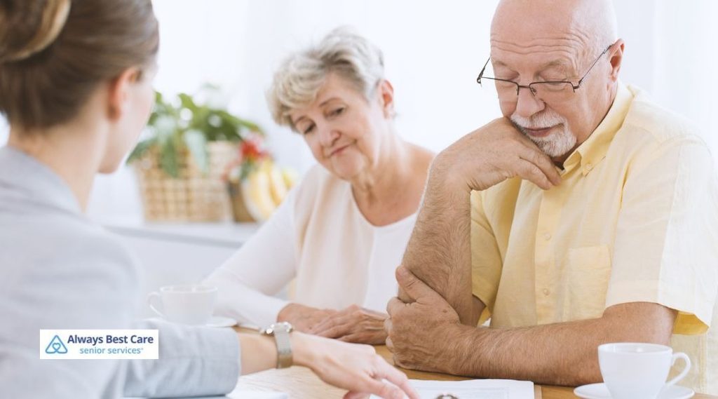 HOW ALEXANDRIA HOME CARE CAN HELP MANAGE BREAST CANCER TREATMENT SIDE EFFECTS: SUPPORT THAT MEETS YOU AT HOME 4 OLDER COUPLE MEETING WITH A CARE PROFESSIONAL TO DISCUSS IN-HOME SUPPORT OPTIONS.