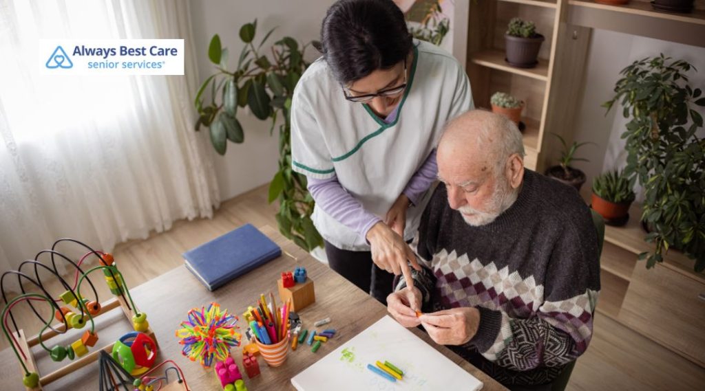 Senior care professional helping an older adult with arts and crafts for memory and cognitive stimulation.