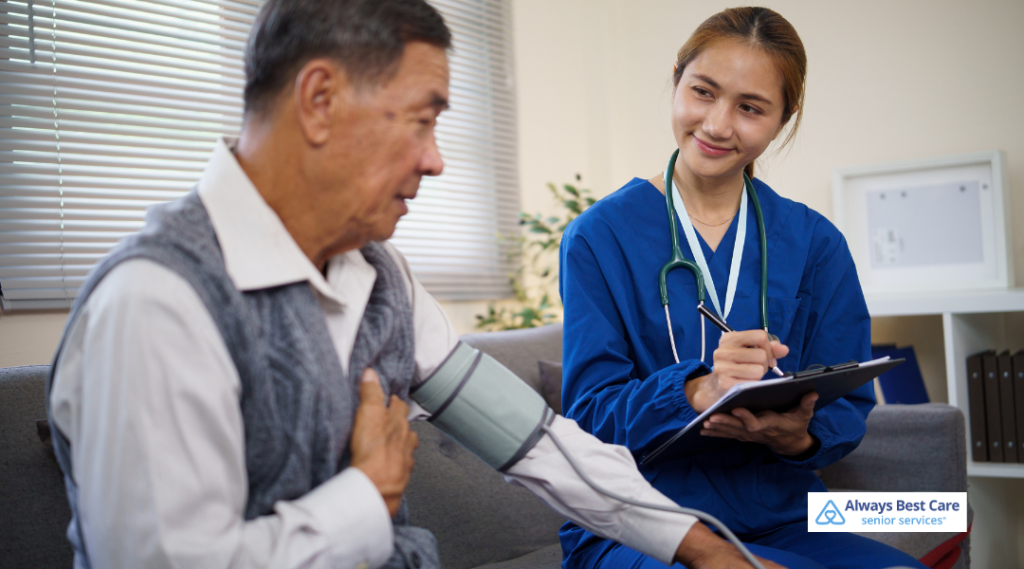 Home health nurse checks an older man’s blood pressure during an in-home care visit, supporting senior heart health and routine monitoring.