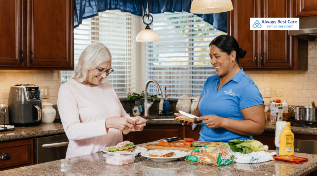 1. Caregiver and senior woman preparing a fresh sandwich together on a kitchen counter.