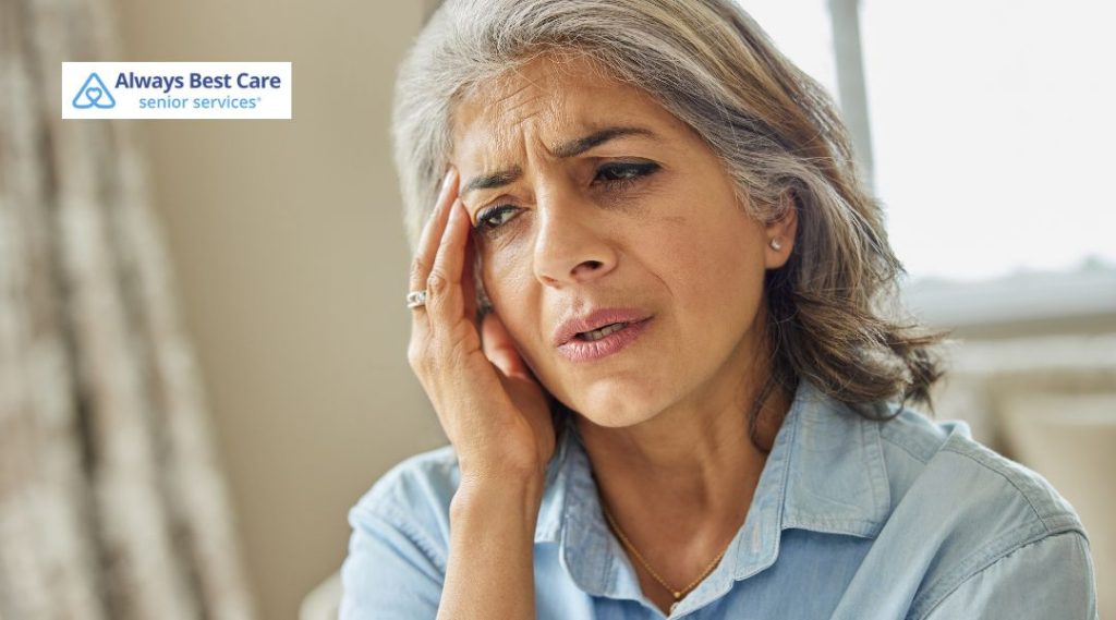 Senior caregiver providing companionship and conversation with an older adult outdoors at home.
