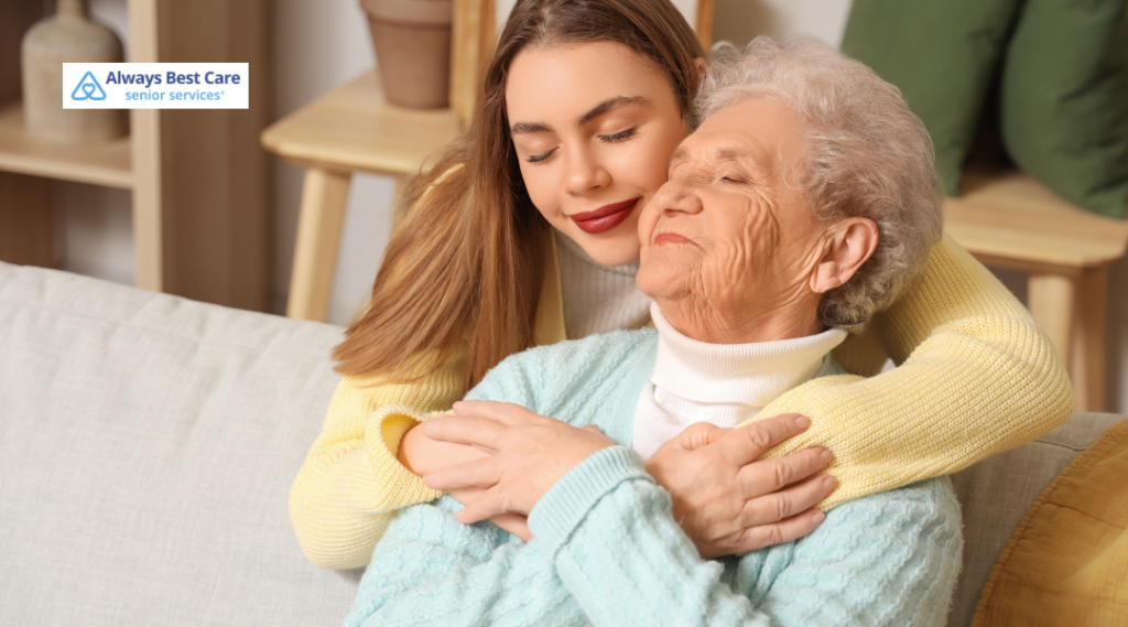 Young woman affectionately embracing an older woman on a couch.

