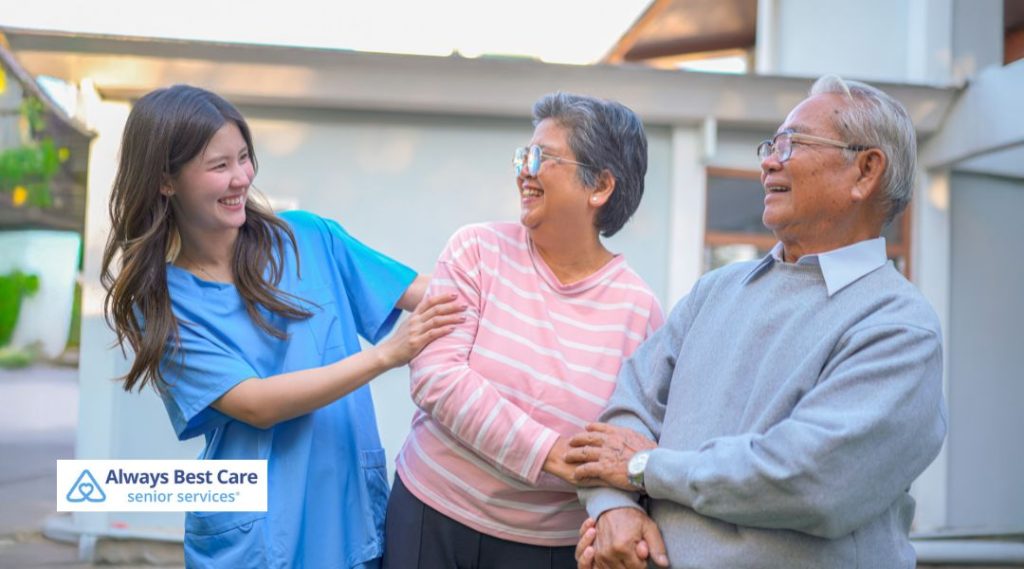 Home care professional walking with and assisting older adults during companion care services.