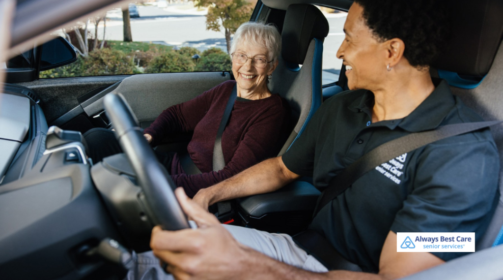 Caregiver driving a senior woman to an appointment, both smiling and talking during the ride.