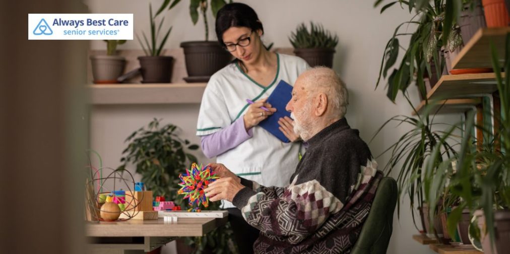 Caregiver assisting an older man with memory activities and cognitive engagement exercises.