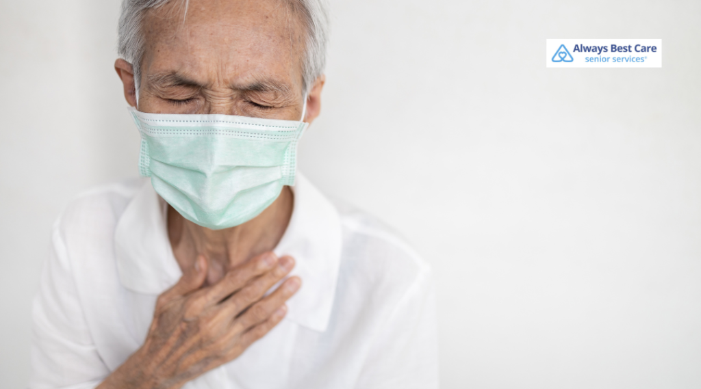 Older man wearing a face mask and holding his chest in discomfort.