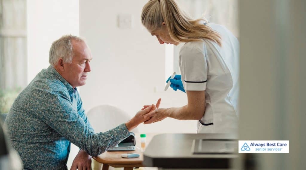 An older man receiving a blood glucose test from a caregiver at home, highlighting the importance of diabetes management for seniors.