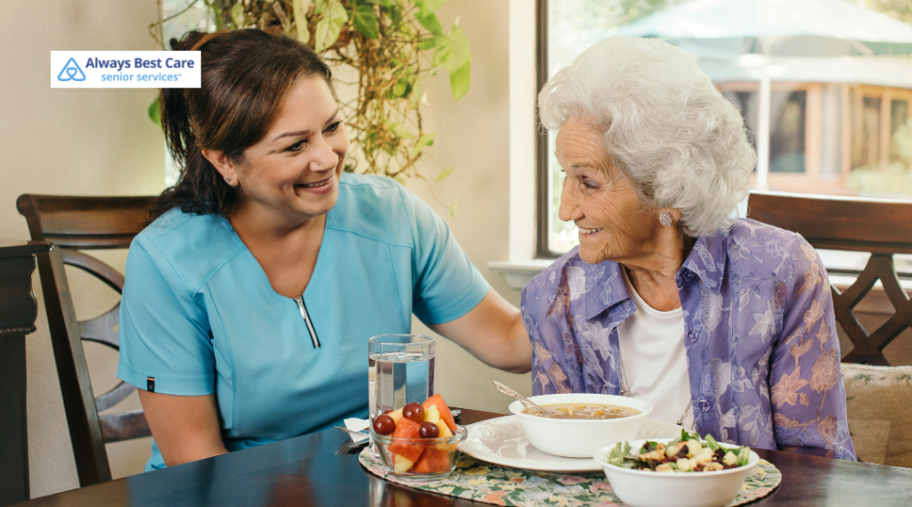 2. Caregiver helping an older woman use a walker in a bright living room.