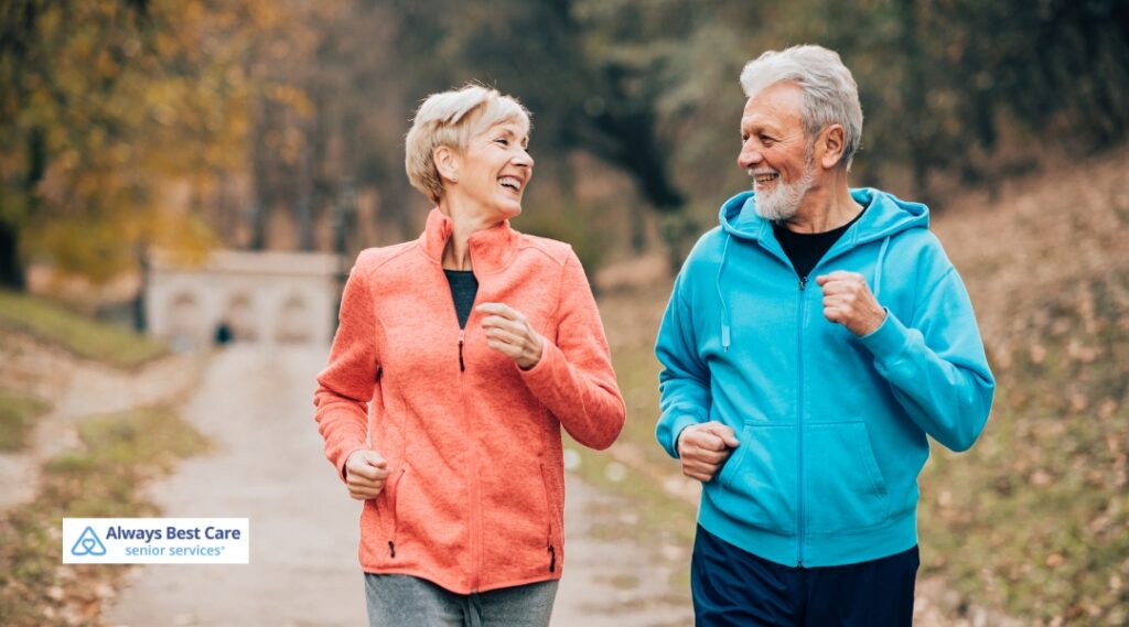 Active senior couple jogging together on an autumn trail to stay healthy as days get shorter
