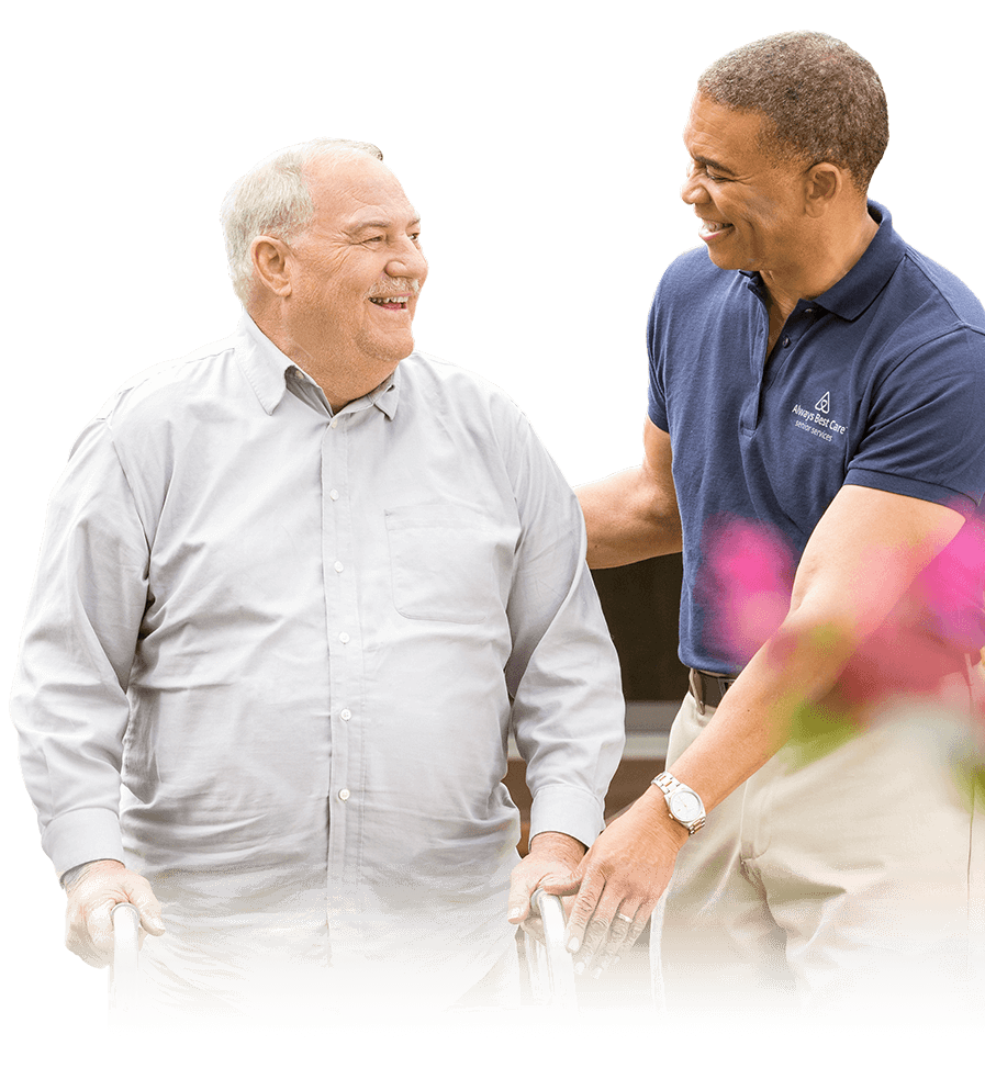 CAREGIVER GUIDING A SENIOR MAN IN A WALKER