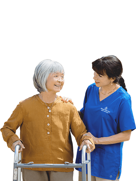 CAREGIVER GUIDING SENIOR WOMAN WHILE WALKING