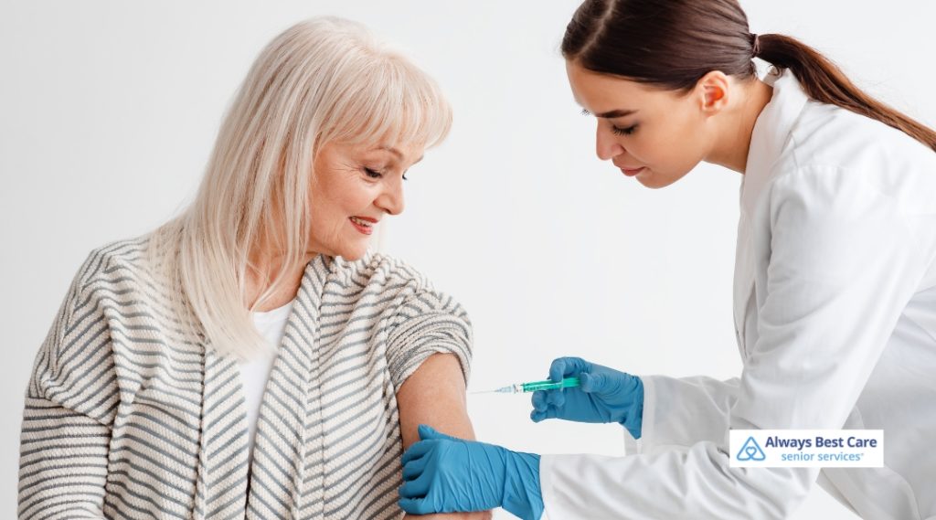 A senior woman receiving a vaccine shot from a healthcare provider in a white coat, with the provider focusing on the injection.