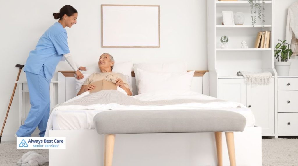 "A caregiver standing beside a senior woman in a bedroom, offering assistance and emotional support. The caregiver is helping the senior with a book, highlighting the personal connection in home care