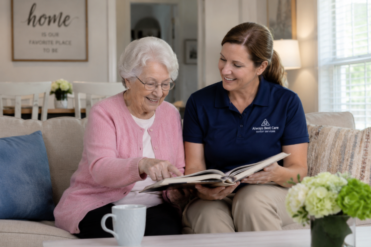 Caregiver and senior woman looking through a photo album together in a comfortable living room, highlighting companionship and personalized home care in Knoxville, TN