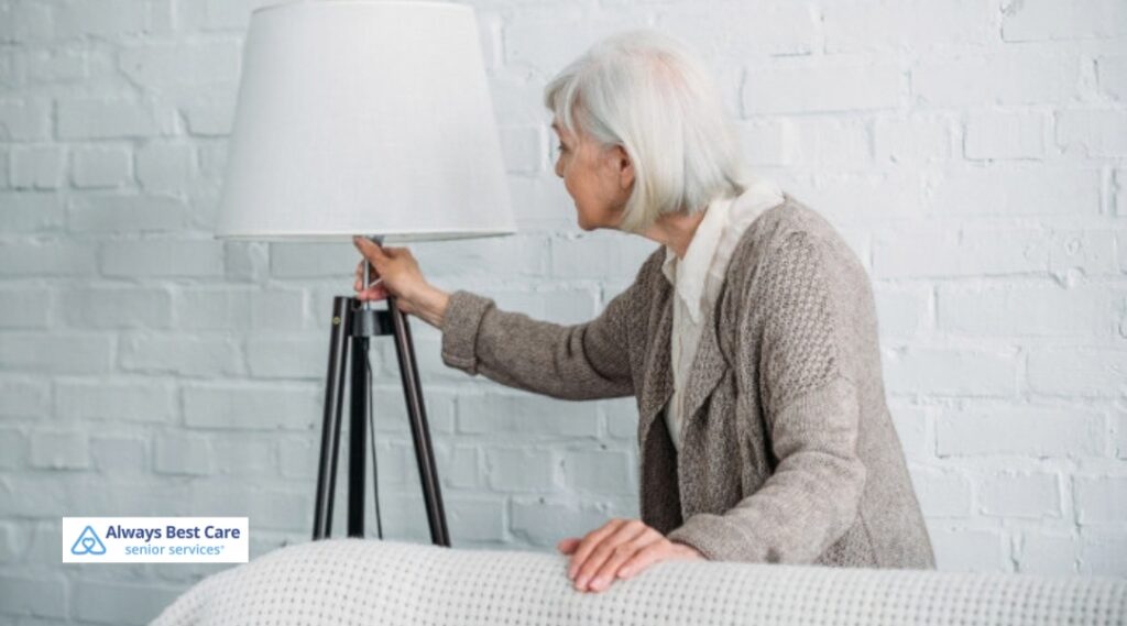 Senior woman turning on a floor lamp to brighten her home during darker fall evenings