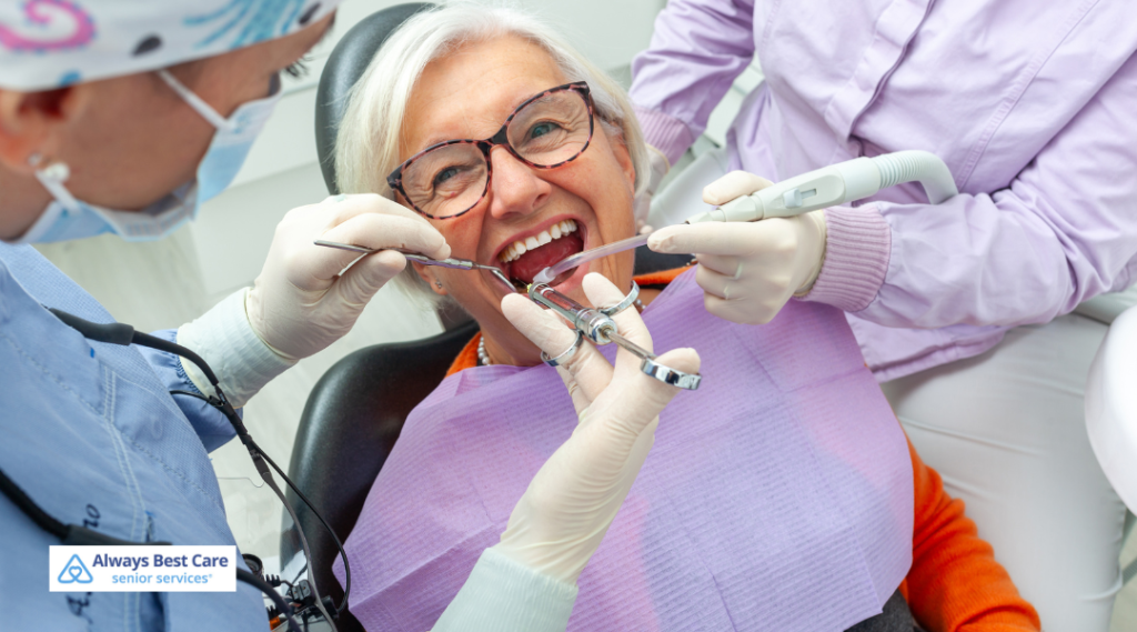 A smiling senior woman receiving dental care, surrounded by dental professionals in protective gear. 