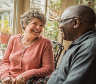 CAREGIVER AND SENIOR SHARING A RELAXED CONVERSATION AT HOME, REPRESENTING COMPASSIONATE HOME CARE SERVICES IN MADISON, WI THAT FOSTER COMPANIONSHIP, COMFORT, AND PERSONALIZED SUPPORT.
