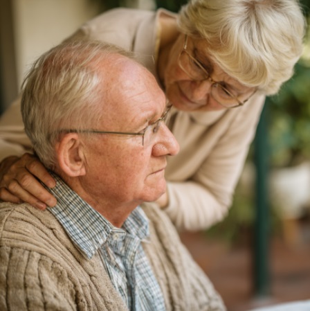 elderly woman gently comforting senior man at home while supporting early Alzheimer’s care and emotional well-being in Madison, WI.