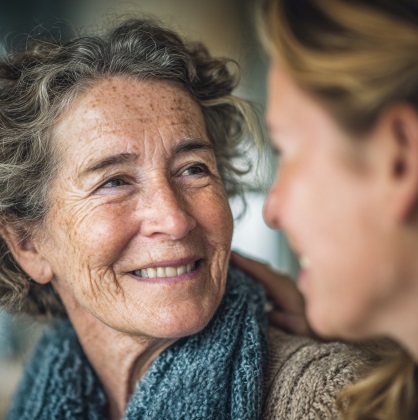 HELPING LOVED ONES WITH MEMORY LOSS 3 SENIOR WOMAN SMILING DURING A SUPPORTIVE CONVERSATION ABOUT MEMORY CARE AND EMOTIONAL WELLNESS IN VERONA, WI.
