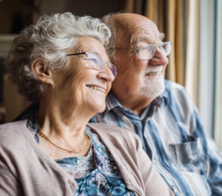 HELPING SENIORS FEEL COMFORTABLE AND CONNECTED 3 SMILING SENIOR COUPLE ENJOYING PEACEFUL COMPANIONSHIP NEAR WINDOW IN VERONA, WI.