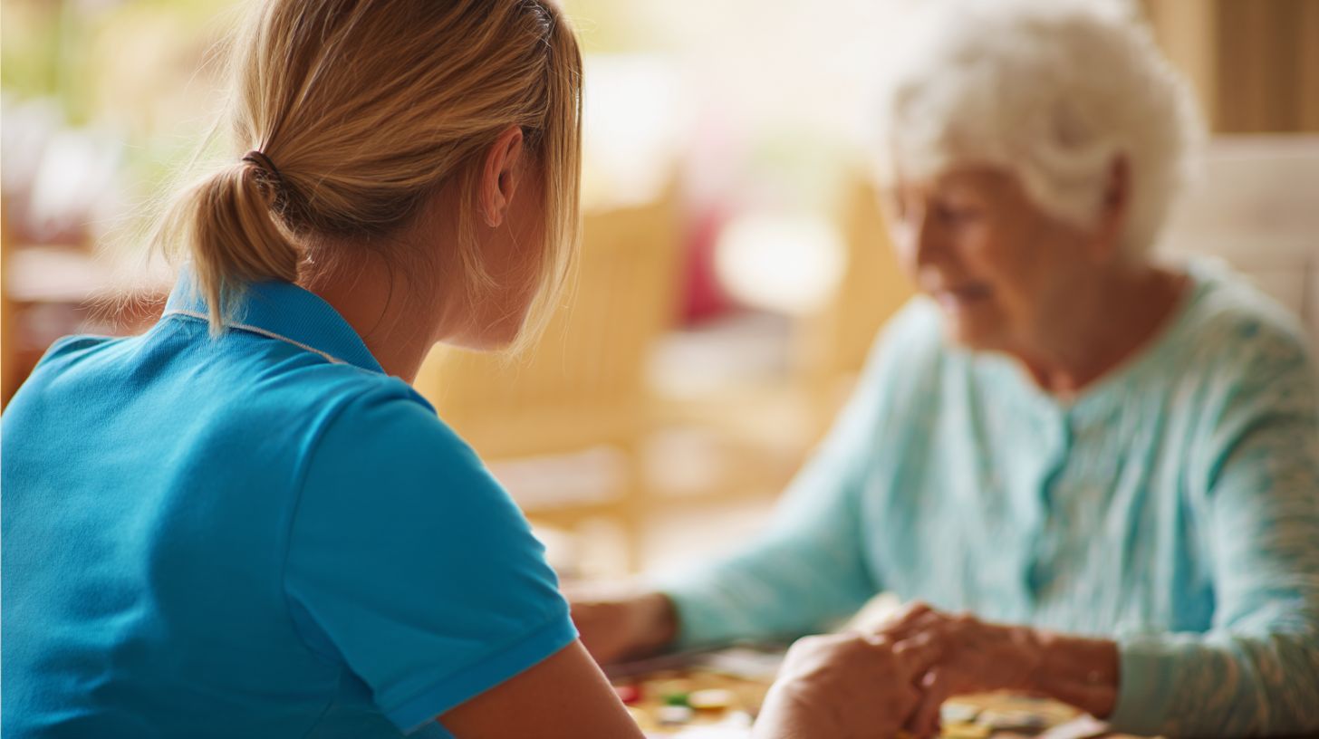 COMPASSIONATE HOME CARE CHESAPEAKE, VA CAREGIVER PLAYING A BOARD GAME WITH AN ELDERLY SENIOR AT A BRIGHT TABLE