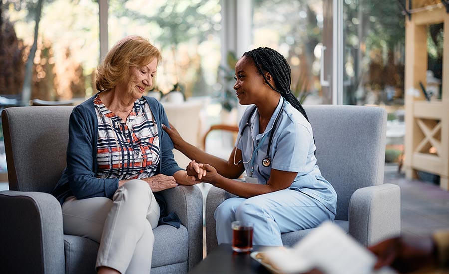 A younger caregiver is caring for an older woman