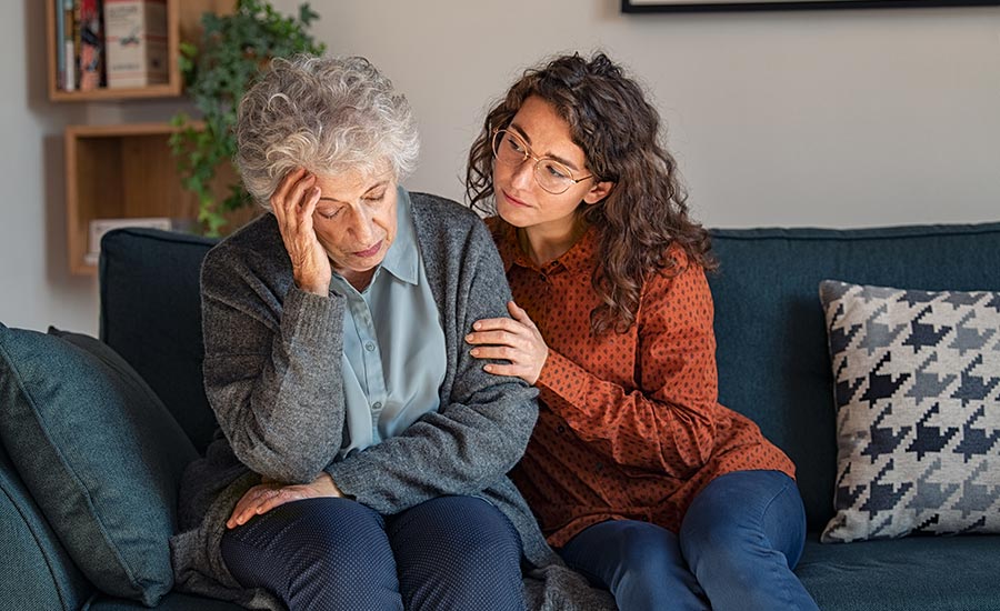 A young caregiver talking to a senior
