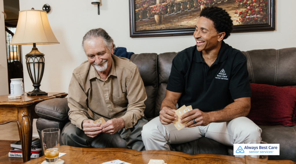 Older adult enjoying a card game with an Always Best Care caregiver, sharing conversation and companionship at home.