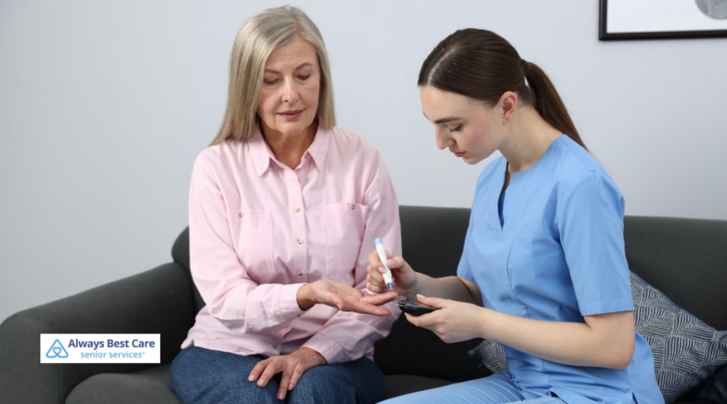 Always Best Care caregiver using a lancing device to check the blood sugar of a senior woman sitting beside her on a couch.