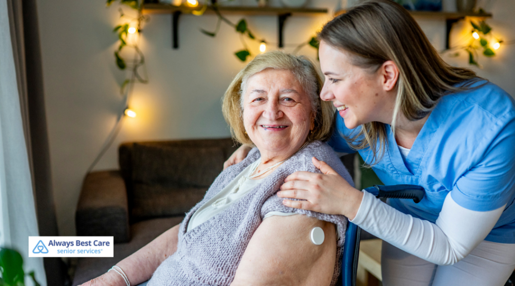 Smiling Always Best Care caregiver embracing a happy senior woman wearing a continuous glucose monitor on her arm.
