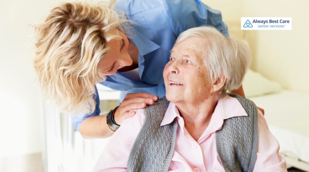 A caregiver and an elderly woman are having an intimate and caring conversation, with the caregiver providing support as the woman smiles, radiating warmth and trust.