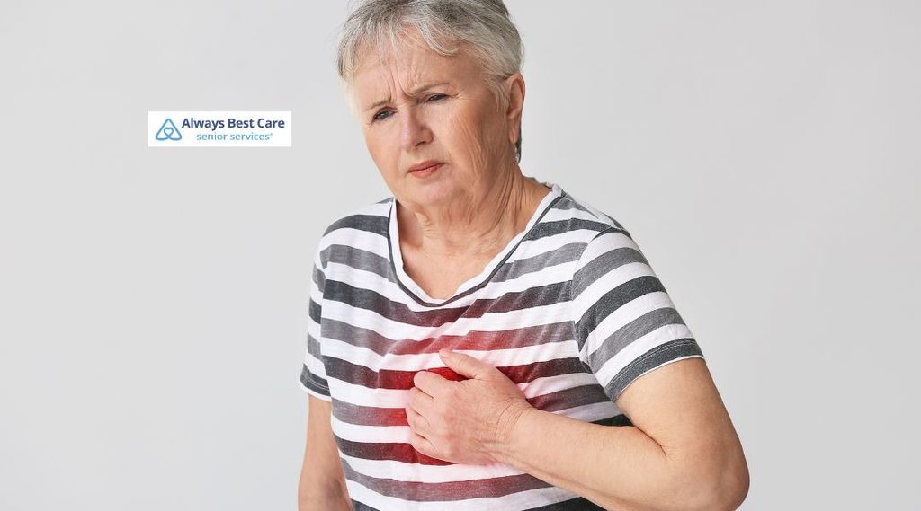 Older woman holding her chest and appearing concerned, illustrating possible chest discomfort or a heart-health emergency.