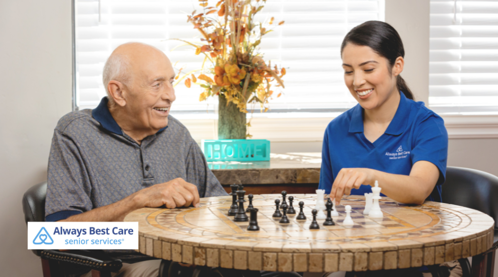 A caregiver and a senior man engage in a game of chess, promoting companionship and mental stimulation as part of in-home care services.
