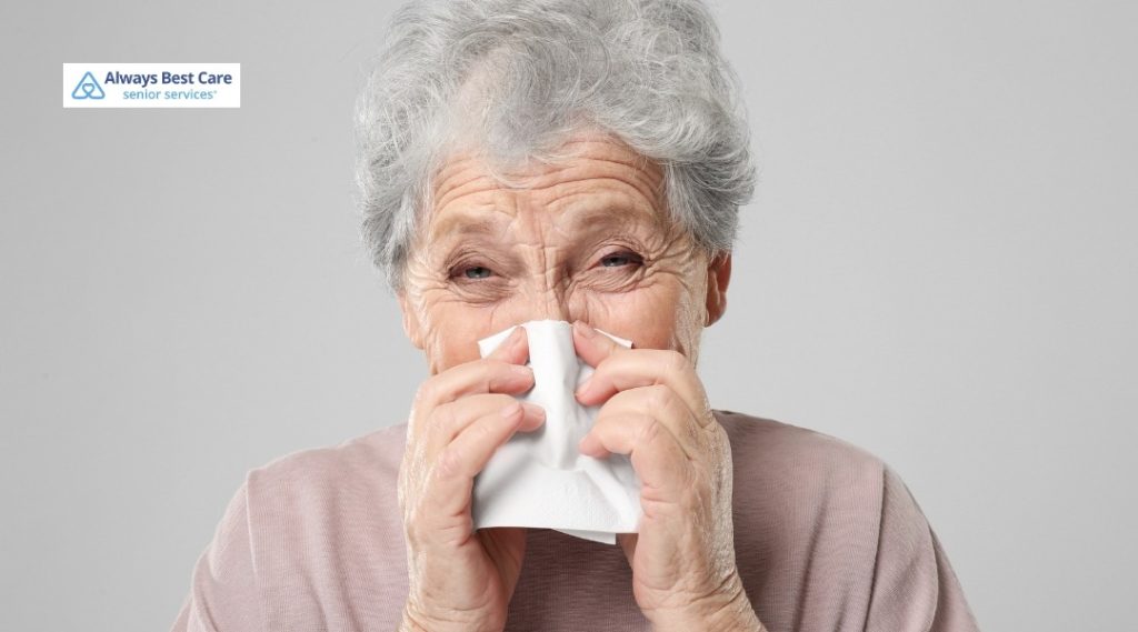 Older woman with short gray hair sneezing into a tissue, representing a senior feeling unwell.