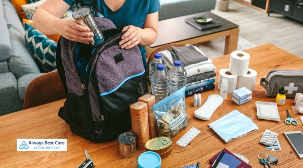 Home emergency preparedness kit with food, water, medications, and supplies on a table.