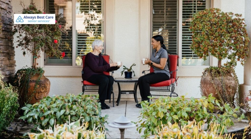  Older woman and caregiver enjoying tea together on a patio.
