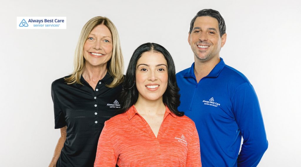 Three Always Best Care staff members, two women and one man, standing side by side in branded polo shirts and smiling at the camera.