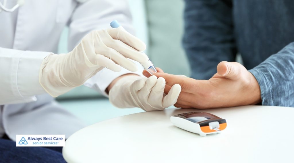 A healthcare professional performs a blood glucose test on a senior man’s finger to monitor his diabetes, highlighting in-home care support.