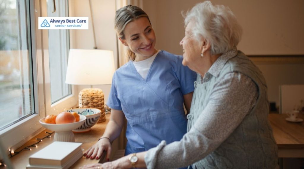 Caregiver sharing a warm conversation with an older woman at home, providing companionship and reassurance during the winter season.