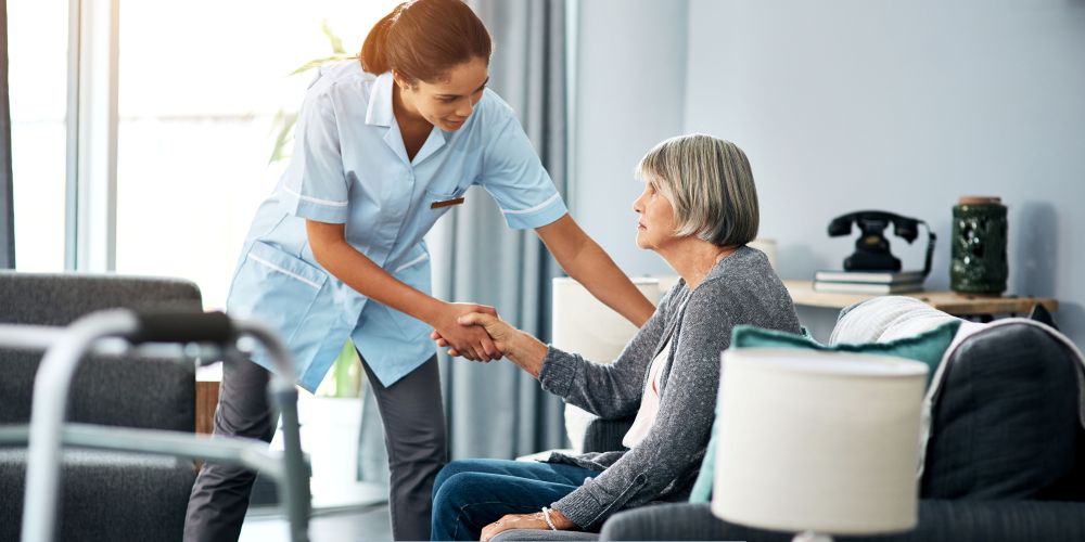 Caregiver helping an older adult stand safely at home while providing supportive home care services in Studio City, CA