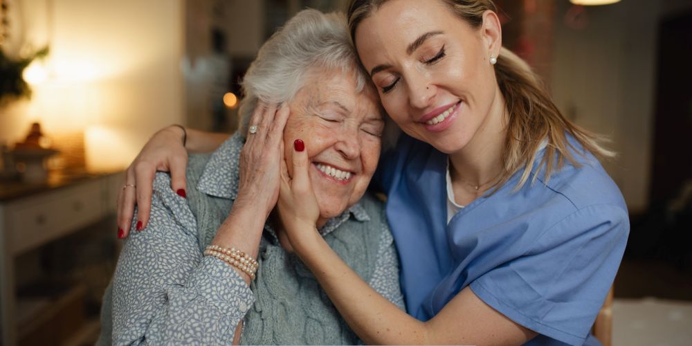 Compassionate caregiver comforting an older adult at home while providing supportive home care services in Valley Village, CA