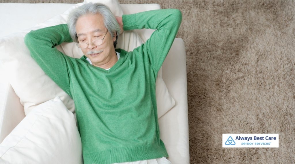 Senior man napping on a couch.
