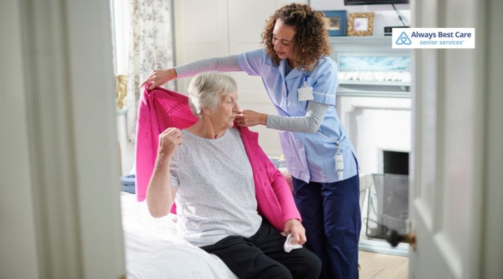 Caregiver helping a senior woman with light movement and stretching at home