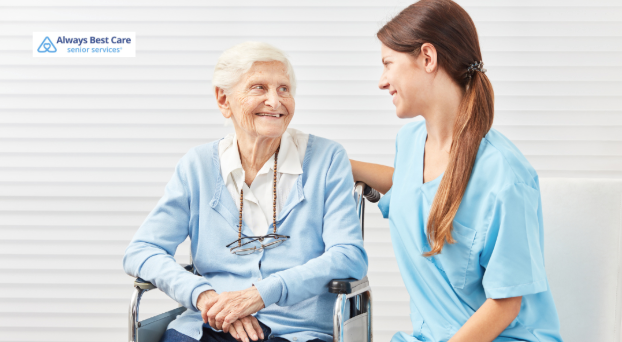 A cheerful caregiver talks with a smiling senior woman in a wheelchair, representing trust, dignity, and compassionate senior care in Thousand Oaks.