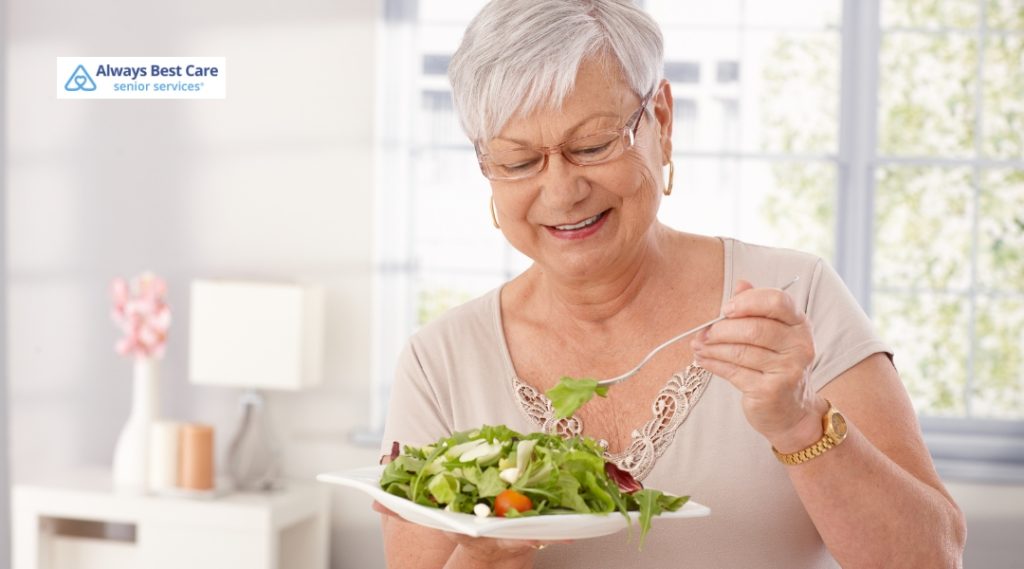 Happy senior woman enjoys a fresh green salad, reinforcing messages of healthy lifestyle and senior self-care.