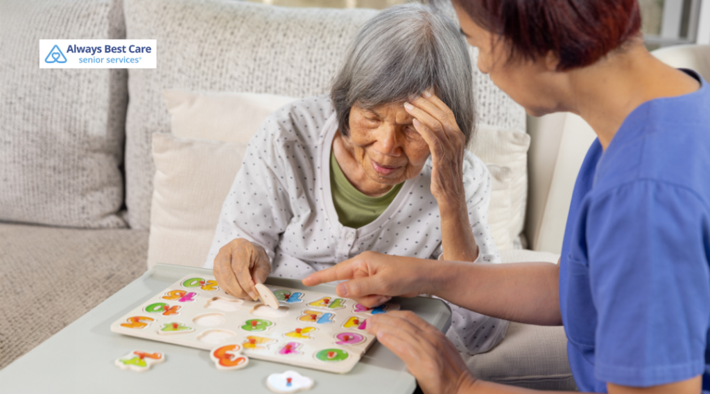 CAREGIVER HELPING AN OLDER WOMAN COMPLETE A COLORFUL MATCHING PUZZLE AT HOME.
