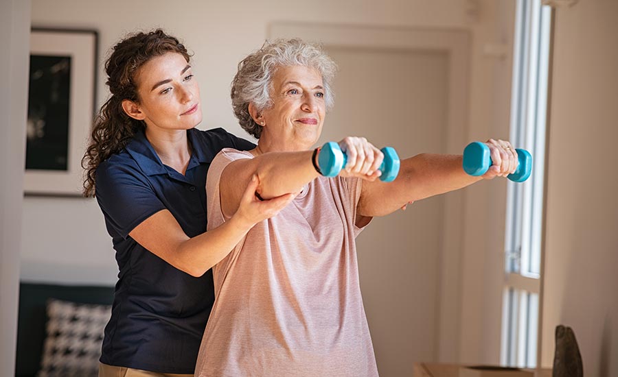 A caregiver helping a senior exercise​
