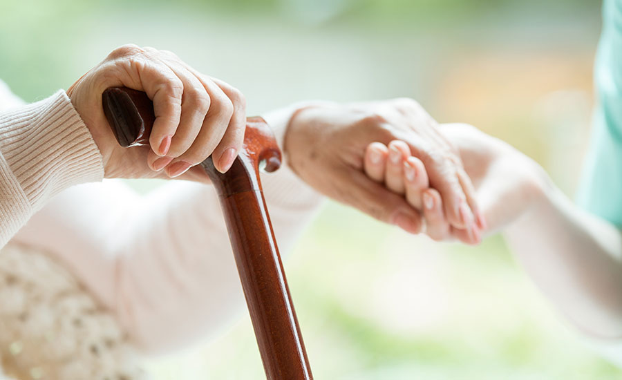 An elderly woman holding a cane​