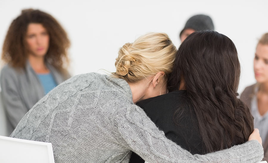 A caregiver hugging another individual​