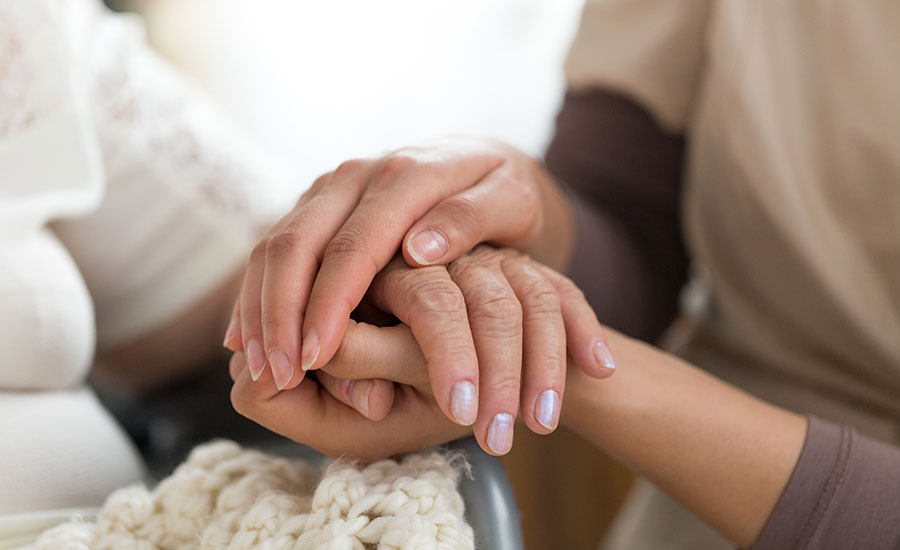 A caregiver holding a senior's hand​